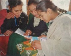 Women conferring with pens and papers